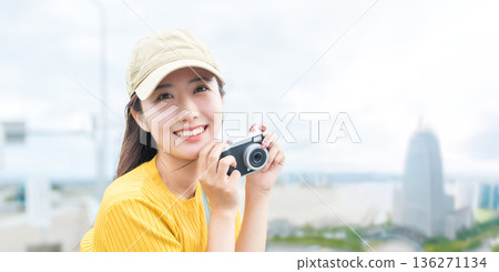 A woman holding a camera at the airport. Photo courtesy of Kansai International Airport (KIX). A woman holding a camera at the airport. Photo courtesy of Kansai International Airport (KIX). 136271134