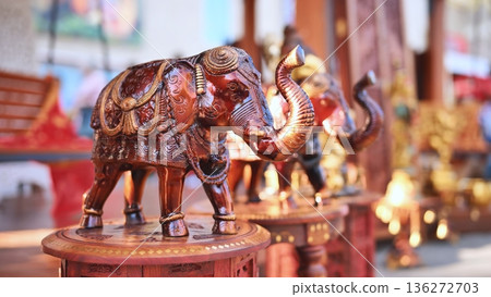 Handcrafted wooden elephant figurine with golden details, traditional Indian souvenir 136272703