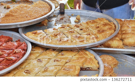 Various trays of sweet baklava and Arabian desserts at an outdoor market stall Various trays of sweet baklava and Arabian desserts at an outdoor market stall 136272711
