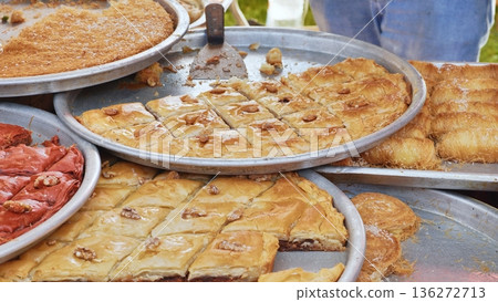Assortment of sweet baklava and kadayif pastries at a street food market stall Assortment of sweet baklava and kadayif pastries at a street food market stall 136272713