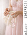 Elegant Woman in Lavender Dress Handling Pearl Jewelry and Lace 136273924