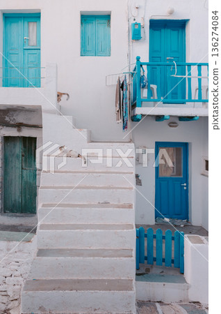 One cat rests on white stairs, another moves by blue doors Folegandros One cat rests on white stairs, another moves by blue doors Folegandros 136274084