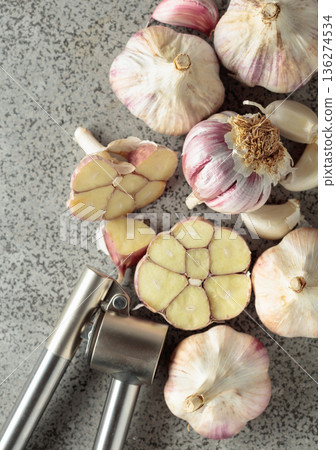 Garlic and garlic press on a kitchen table. 136274534