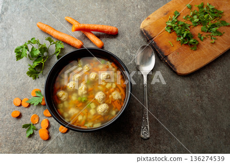 Classic meatball soup with potatoes,  carrot and greens. 136274539