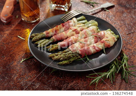 Grilled green asparagus with bacon on a brown vintage background. Grilled green asparagus with bacon on a brown vintage background. 136274548