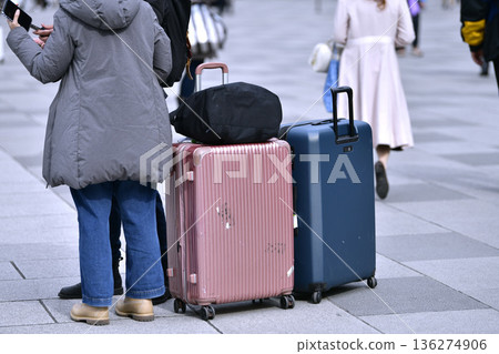Tokyo cityscape in Japan. Suitcases... The Marunouchi Square in front of Tokyo Station is bustling with foreign tourists. They're preparing their selfie sticks... Tokyo cityscape in Japan. Suitcases... The Marunouchi Square in front of Tokyo Station is bustling with foreign tourists. They're preparing their selfie sticks... 136274906