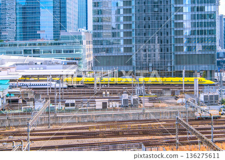 Tokyo cityscape in Japan. View of the Shinkansen bullet train Doctor Yellow, which brings good luck, Tokyo Station, trains, Yaesu and other buildings. Tokyo cityscape in Japan. View of the Shinkansen bullet train Doctor Yellow, which brings good luck, Tokyo Station, trains, Yaesu and other buildings. 136275611