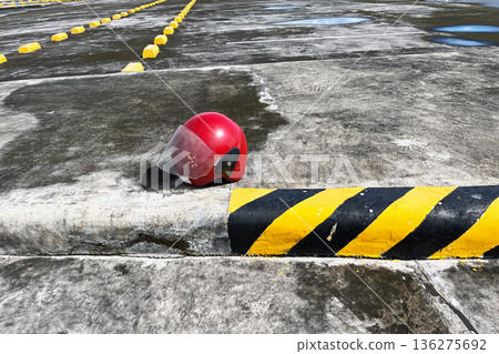 red open face motorcycle helmet with visor on concrete parking lot near yellow and black curb 136275692