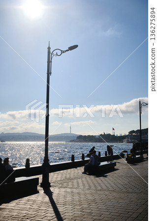 Seaside promenade with lamppost and benches in sunlight Seaside promenade with lamppost and benches in sunlight 136275894