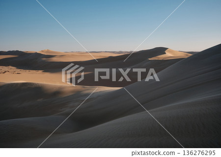 Sand dunes under soft evening light Sand dunes under soft evening light 136276295