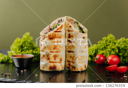Grilled tuna tortilla wraps with greens, sauce and tomatoes on slate Grilled tuna tortilla wraps with greens, sauce and tomatoes on slate 136276359