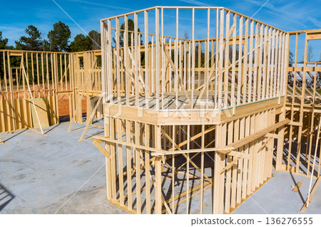 Workers are building wooden house frame, framing beams structure supports in construction site Workers are building wooden house frame, framing beams structure supports in construction site 136276555