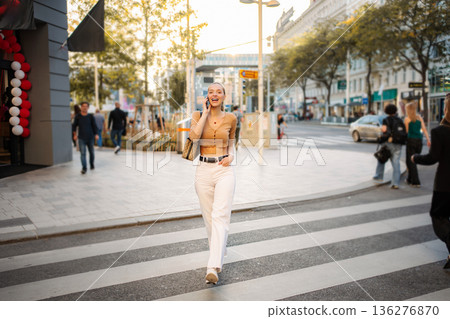 Happy young adult woman talking on phone in Vienna street Happy young adult woman talking on phone in Vienna street 136276870