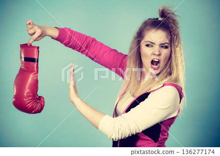 Disgusted woman holding boxing glove Disgusted woman holding boxing glove 136277174