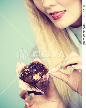 Attractive woman holds cake in hand Attractive woman holds cake in hand 136277188