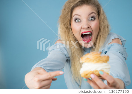 Funny woman holds cream puff cake Funny woman holds cream puff cake 136277190
