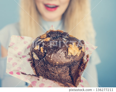 Attractive woman holds cake in hand Attractive woman holds cake in hand 136277211