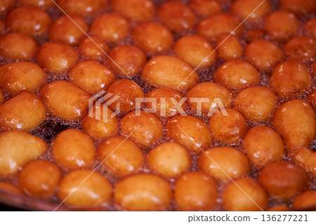 Donuts or doughnuts are made from a mixture of flour, sugar, egg yolks, yeast, and butter. Ball shaped, powdered sugar on a stacked donut 136277221