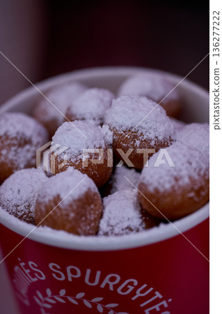 Donuts or doughnuts are made from a mixture of flour, sugar, egg yolks, yeast, and butter. Ball shaped, powdered sugar on a stacked donut 136277222