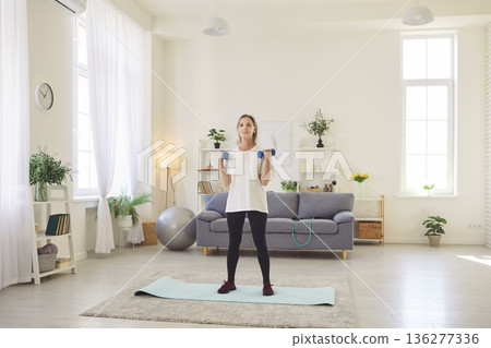 Active Senior Woman Exercising With Dumbbells At Home Active Senior Woman Exercising With Dumbbells At Home 136277336