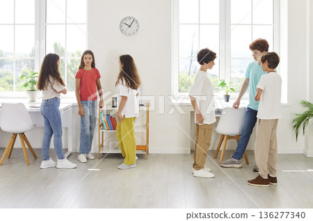 Group Of School Children Communicating Together In Classroom 136277340