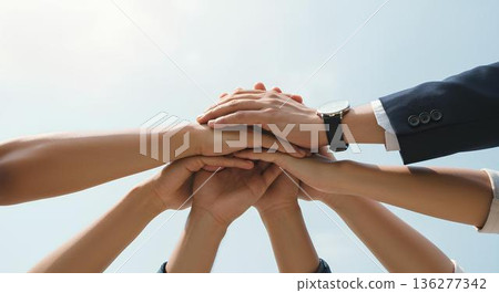 A business team standing together under a blue sky, symbolizing unity, cooperation, success and a bright future. 136277342