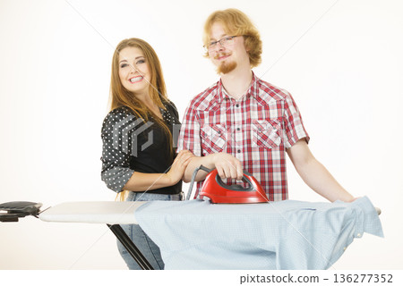 Man and woman couple ironing clothes 136277352