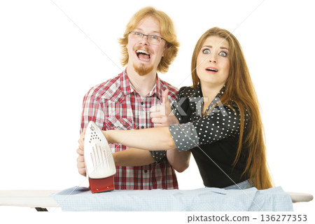Woman teaching men how to do ironing Woman teaching men how to do ironing 136277353