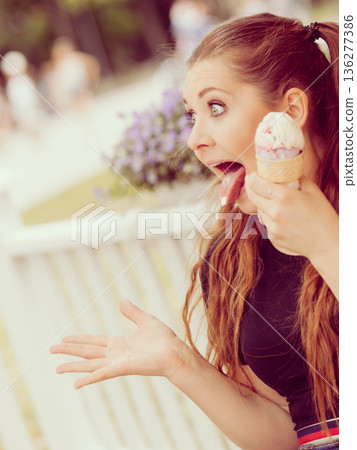 Young woman eating ice cream Young woman eating ice cream 136277386