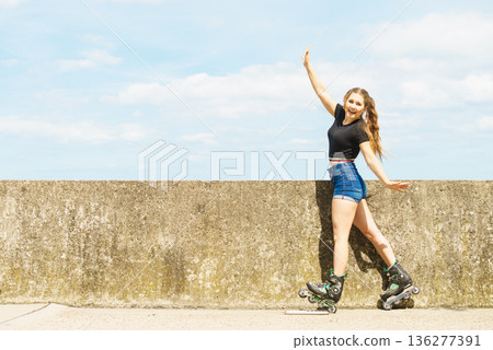 Fit girl with roller skates outdoor Fit girl with roller skates outdoor 136277391