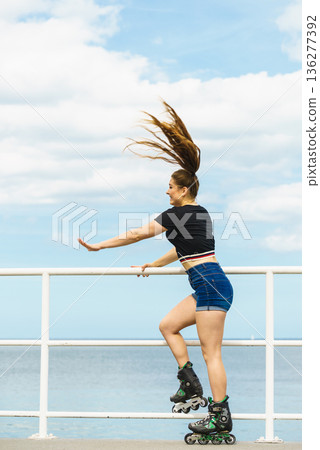 Girl wearing roller skates on seaside Girl wearing roller skates on seaside 136277392