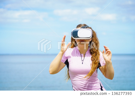 Woman wearing VR outside Woman wearing VR outside 136277393