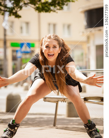 Young woman riding roller skates 136277399