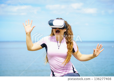 Woman wearing VR outside Woman wearing VR outside 136277408