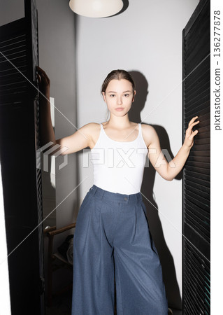 Young woman posing in casual minimalist fashion ensemble 136277878