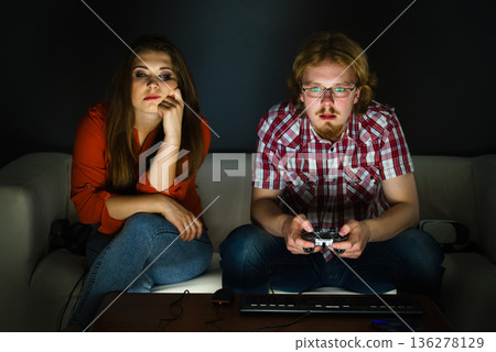 Woman is bored while man playing games Woman is bored while man playing games 136278129