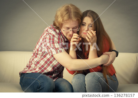 Woman confiding to man on sofa 136278157