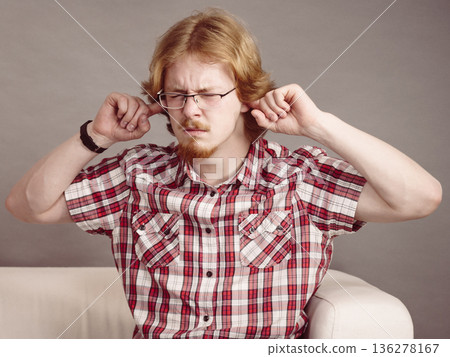 Man being annoyed with noise Man being annoyed with noise 136278167