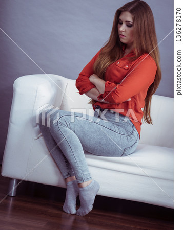 Angry woman sitting on sofa Angry woman sitting on sofa 136278170
