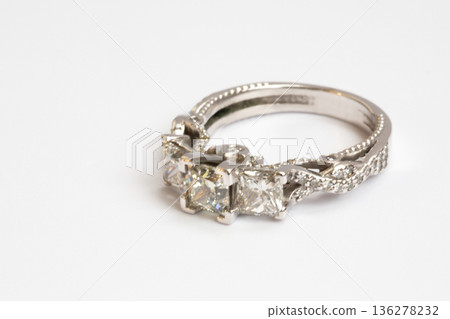 Engagement diamond wedding ring group on white. A white gold ring with large natural princess-cut or Square Modified Brilliant diamonds. Engagement diamond wedding ring group on white. A white gold ring with large natural princess-cut or Square Modified Brilliant diamonds. 136278232