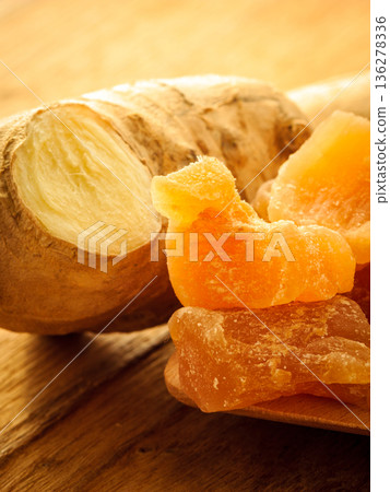 Closeup root and candied ginger on wooden table Closeup root and candied ginger on wooden table 136278336