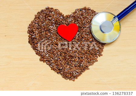 Raw flax seeds heart shaped and stethoscope Raw flax seeds heart shaped and stethoscope 136278337