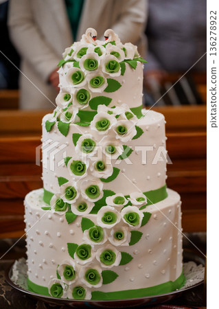 Elegant Three-Tier Wedding Cake with White and Green Fondant Roses and Swan Decorations 136278922