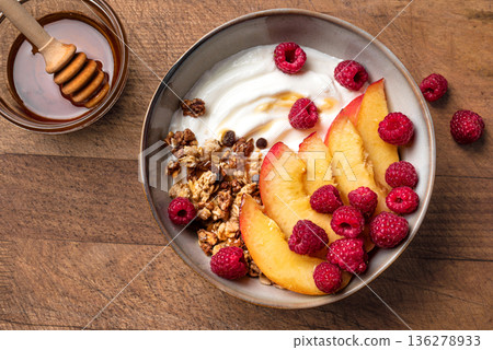 Granola bowl with greek yogurt, peach, raspberry and honey 136278933