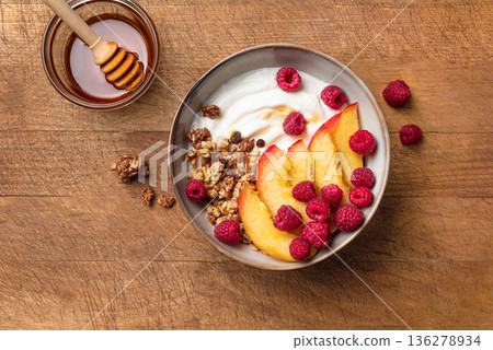 Granola bowl with greek yogurt, peach, raspberry and honey 136278934