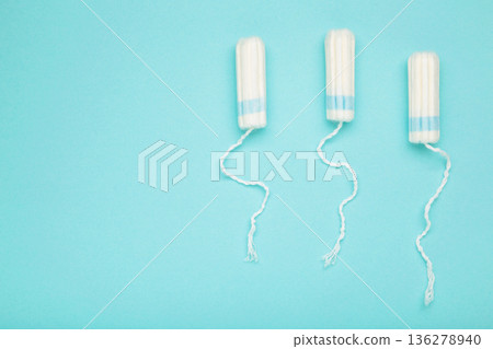 Cotton tampons for women hygiene menstrual period on blue background. Top view 136278940