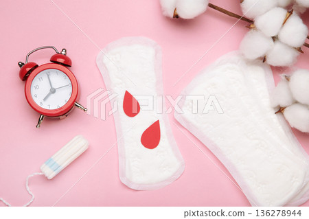 Sanitary pad and tampon with cotton flower on pink background. Daily feminine hygiene product. Menstruation and womens health concept. Copy space. 136278944