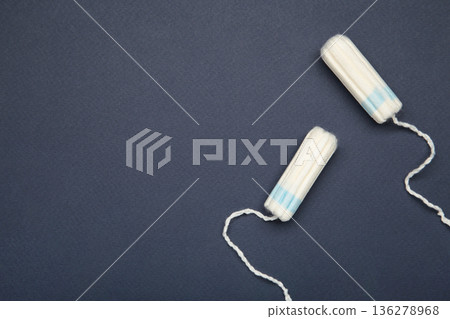 Cotton tampons for women hygiene menstrual period on dark blue background. 136278968