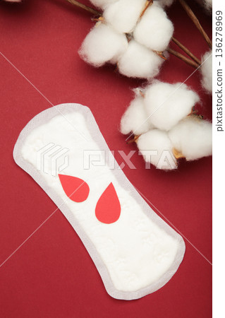 Menstrual pad with paper blood drop on red background 136278969