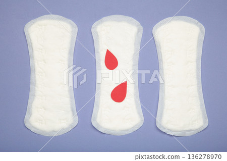 Menstrual pad with paper blood drop on purple background Menstrual pad with paper blood drop on purple background 136278970
